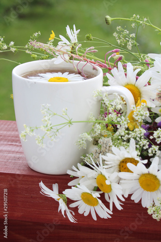 A cup of tea with daisies bouquet 