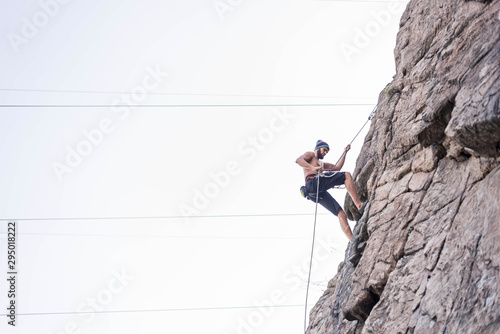 Man cliff climber is climbing a rock.