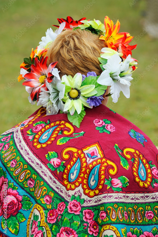 woman in a national scarf with ornament and hairstyle decorated with a wreath of flowers