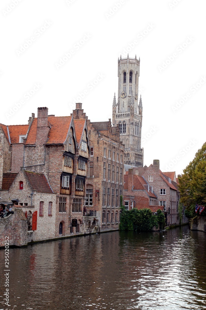 Belfry Tower (aka Belfort) and canal of Bruges city in autumn, medieval historic city. popular tourist destination of Belgium