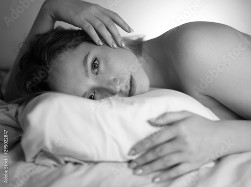 Close up portrait of a beautiful young lady lying on the bed.