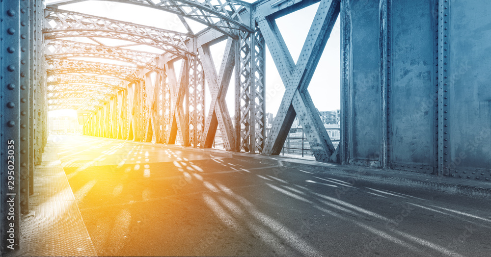Φωτογραφία Asphalt road under the steel construction of a bridge in the city on a sunny day
