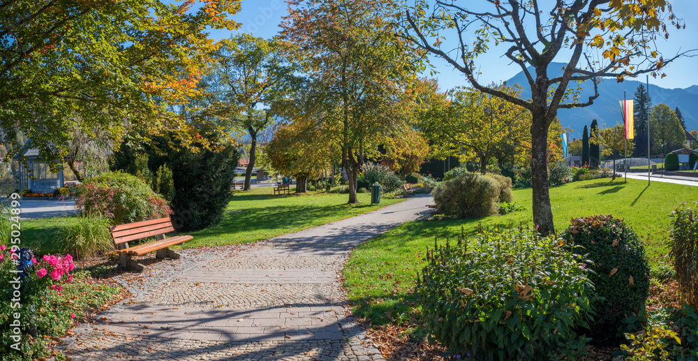 herbstlicher Kurpark Rottach-Egern am Tegernsee, Parkweg und Bank an einem sonnigen Herbsttag herbstlicher Kurpark Rottach-Egern am Tegernsee, Parkweg und Bank an einem sonnigen Herbsttag