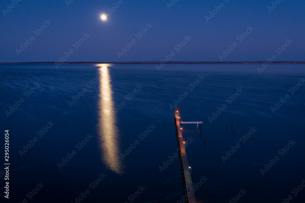 The moon reflected in the ocean and the pier at Ceduna in South Australia