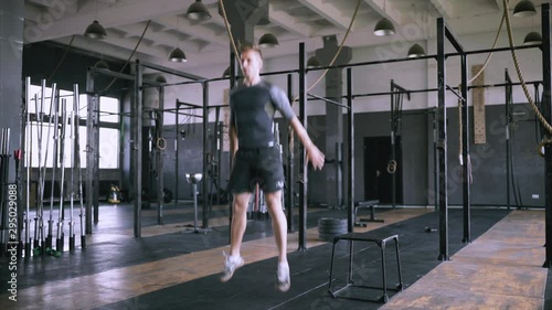 Powerlifting effective jumps. Male fitness instructor showing squat exercise at loft plase. Jumping squats at gym. Effective exercises for a great fit. lunch short workout.