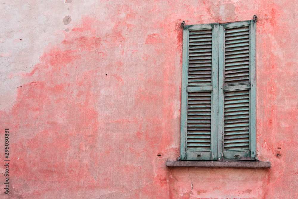 une vieille fenêtre verte et volets verts sur un mur rouge en italie une vieille fenêtre verte et volets verts sur un mur rouge en italie