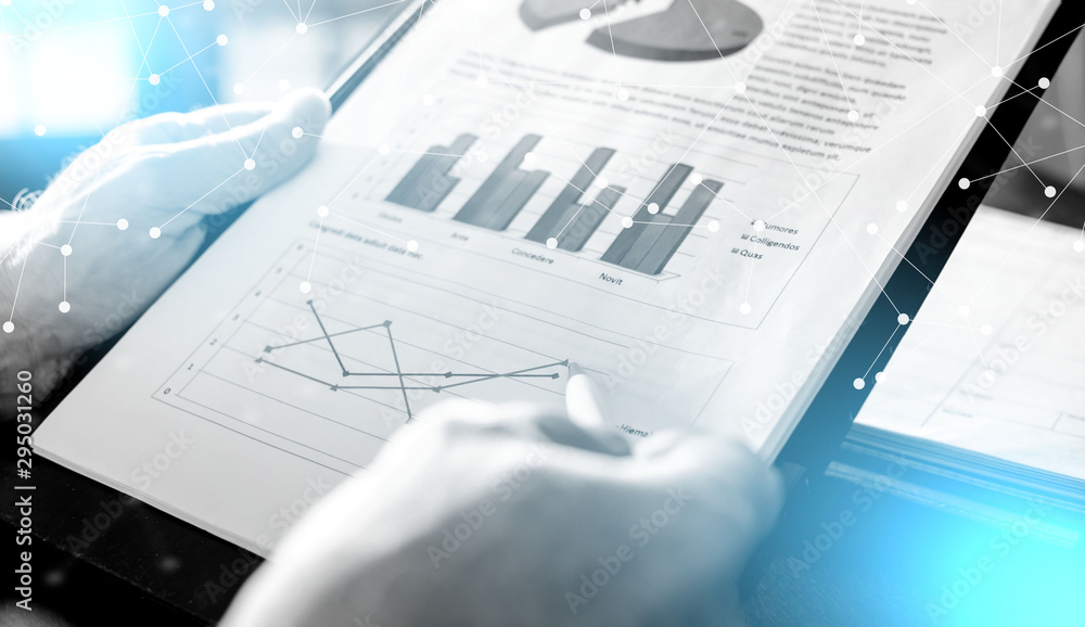Businessman analysing economic graphs; light effect Businessman analysing economic graphs; light effect