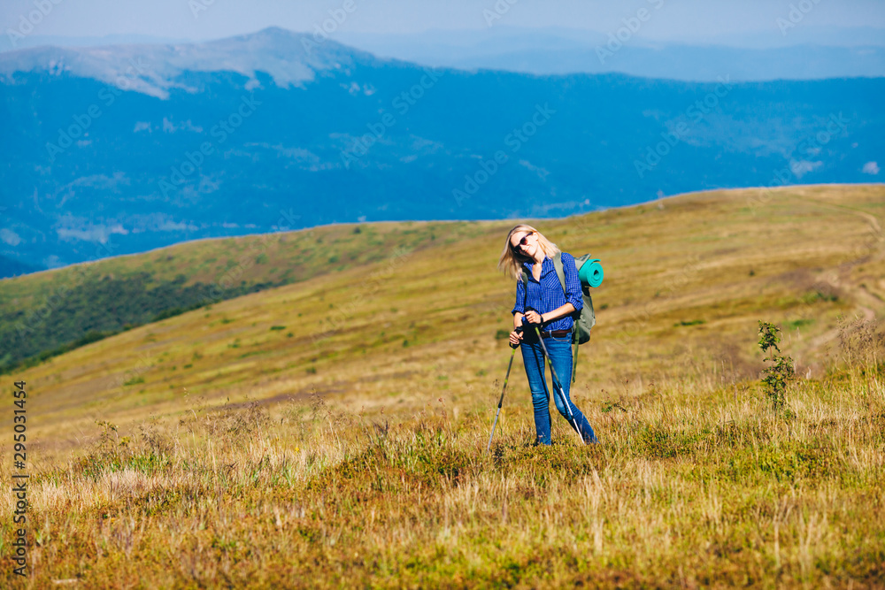 Happy woman hiking in the mountains. Freedom and achievement concept