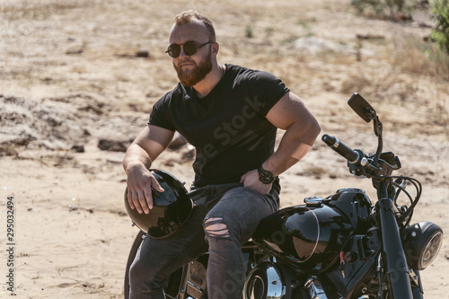 Brutal attractive male posing on bike with helmet