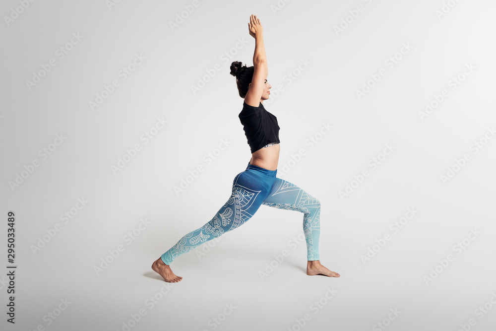 Yoga warrior pose with hands above head, stretching, hands above head, woman on white backgroung, studio photos