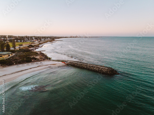 An empty and calm Cottesloe beach at sunrise. Peaceful morning as the sun rises over the city. 