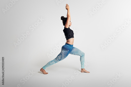 Yoga warrior pose with hands above head, stretching, hands above head, woman on white backgroung, studio photos