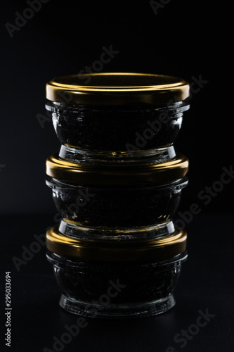 Glass jars with black sturgeon caviar.