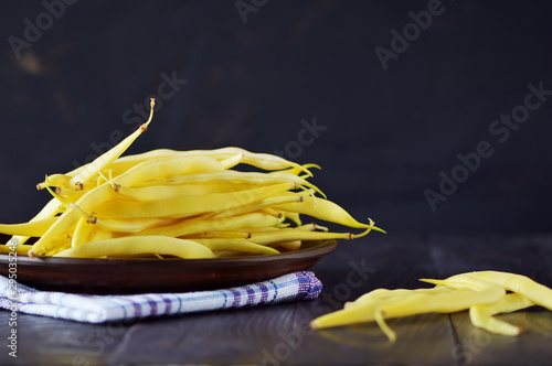 Yellow bean pods. Fresh vegetables on the table. Cutting a delicious salad for vegetarians. 
