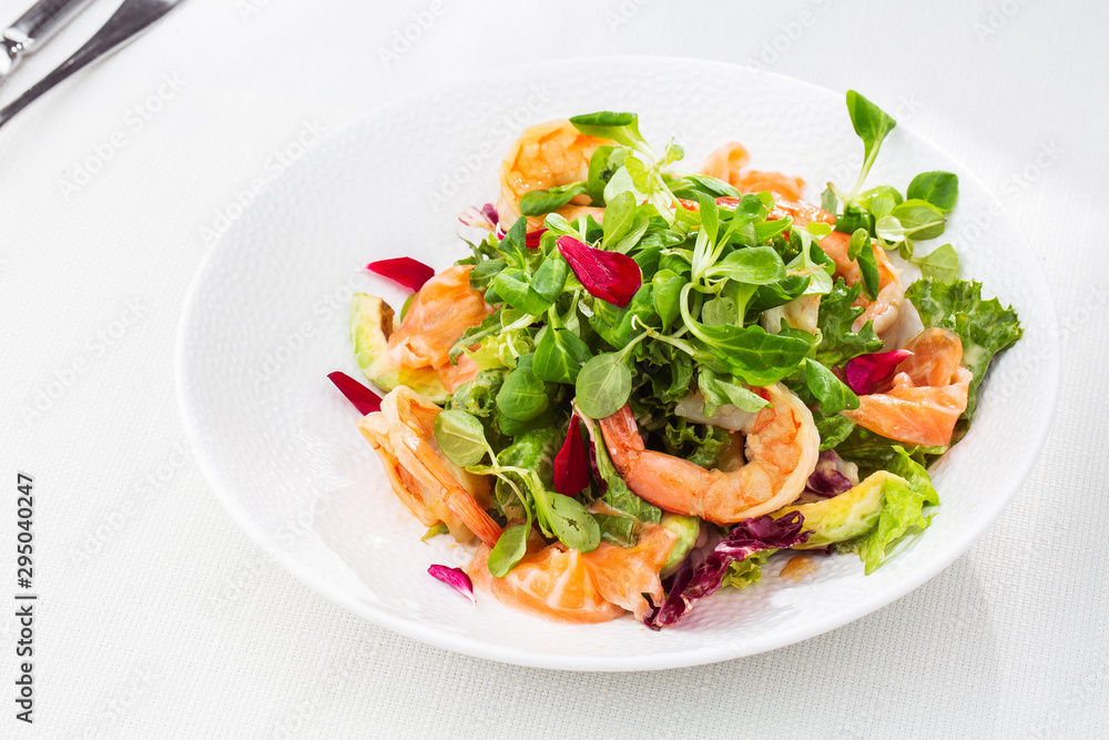 Healthy Salad. Recipe for fresh seafood. Grilled shrimps, prawns, fresh salad lettuce and avocado slices. Healthy Eating. White background. Horizontal photo. Healthy Salad. Recipe for fresh seafood. Grilled shrimps, prawns, fresh salad lettuce and avocado slices. Healthy Eating. White background. Horizontal photo.