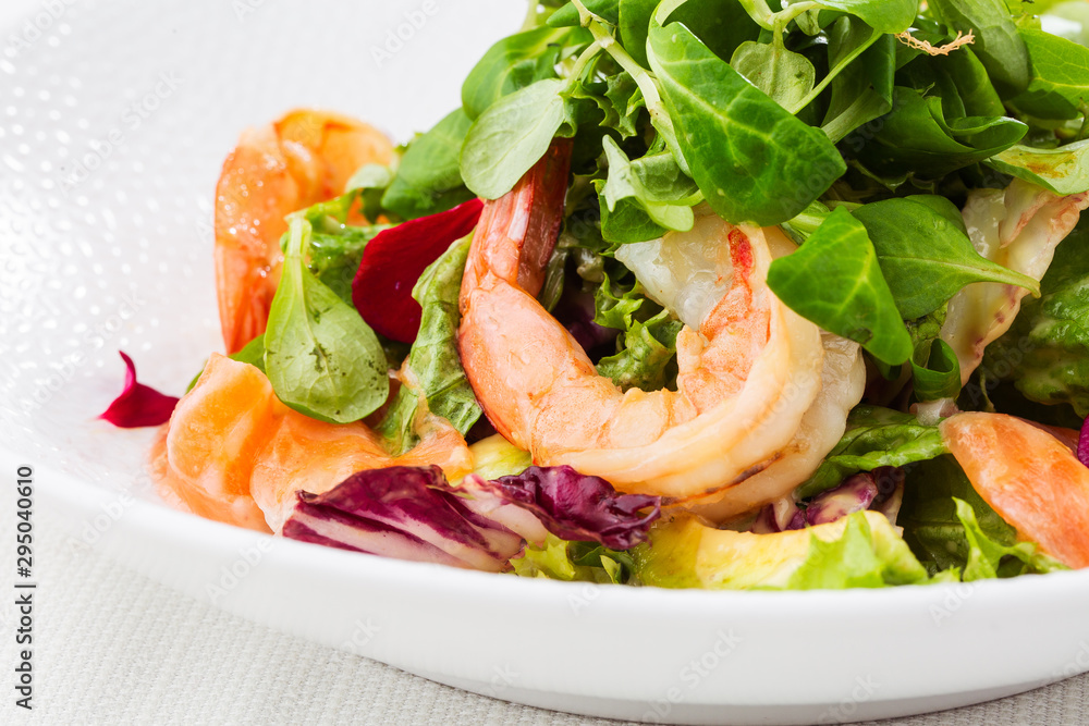 Healthy Salad. Recipe for fresh seafood. Grilled shrimps, prawns, fresh salad lettuce and avocado slices. Healthy Eating. White background. Horizontal photo. Healthy Salad. Recipe for fresh seafood. Grilled shrimps, prawns, fresh salad lettuce and avocado slices. Healthy Eating. White background. Horizontal photo.