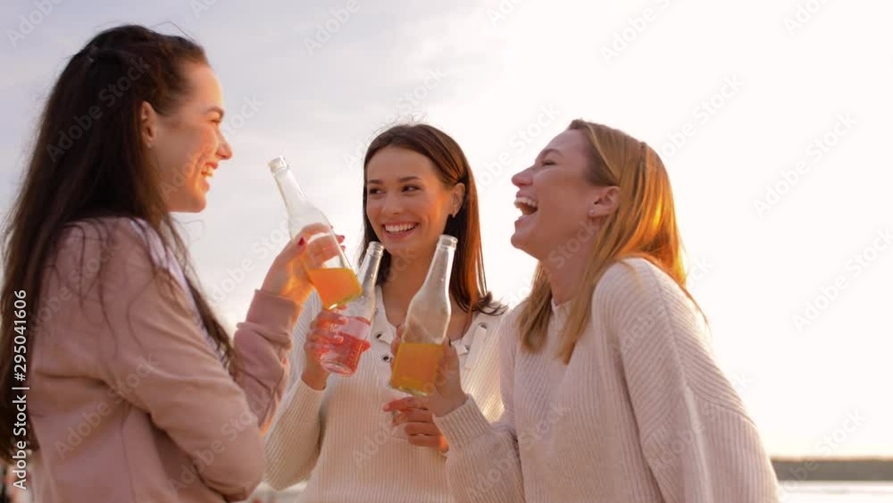 friendship and leisure concept - group of happy young women or female friends toasting non alcoholic drinks on summer beach friendship and leisure concept - group of happy young women or female friends toasting non alcoholic drinks on summer beach
