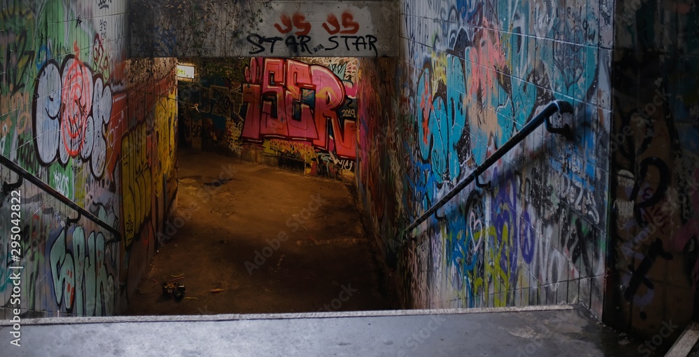 Abandoned underground passageway with old graffiti and old postcards on the walls - obrazy, fototapety, plakaty 