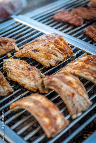Grilling pork ribs on a barbecue at a buffet in a restaurant