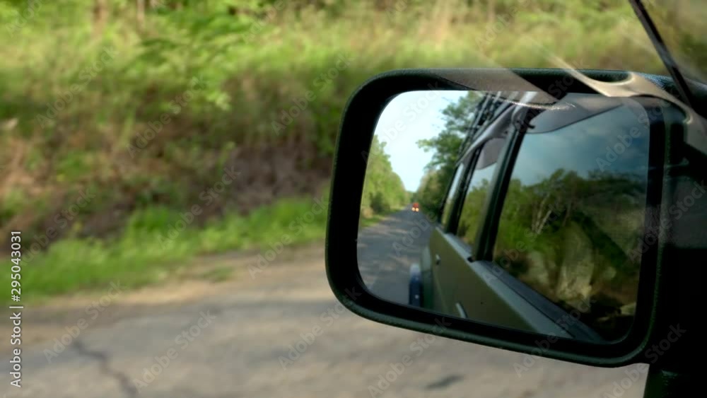 Beautiful view through a car mirror. Shooting a mirror of a moving car on a dirt road. Beautiful view through a car mirror. Shooting a mirror of a moving car on a dirt road.