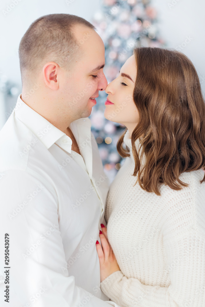 man and woman closed their eyes and hugging. Christmas tree in t man and woman closed their eyes and hugging. Christmas tree in t