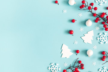 Christmas or winter composition. Snowflakes and red berries on blue background. Christmas, winter, new year concept. Flat lay, top view, copy space