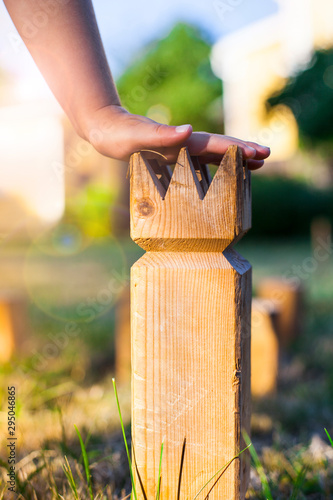 Kubb Wikingerschach. Wurfspiel in Garten. Kind hält König in der Hand. Girl playing Kubb in garden. photo