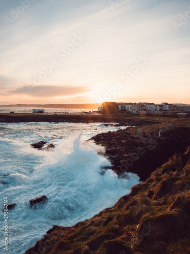 A beautiful sunrise over the quiet and remote Northern Irish coastline. Jagged and rocky landscape with the sea crashing into the cliffs. 
