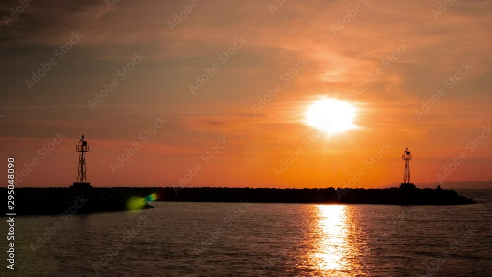 Timelapse of a beautiful sunset with lighthouse silhouette near the beach Timelapse of a beautiful sunset with lighthouse silhouette near the beach