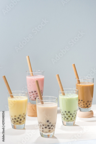 Five glasses of healthy milky boba or bubble tea flavored with fresh fruit and chocolate and served with traditional wide straws
