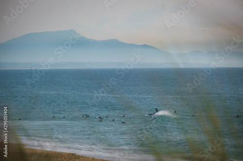 surfers, with pyrenees in the background