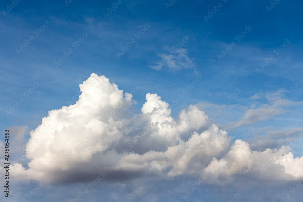 Obraz premium White curly clouds in the dark blue sky_