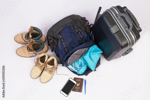 Travel concept with luggage. prepare accessories and items isolated on white background. Travel plan, trip vacation, tourism, Open traveler's bag with clothing.Top view gray suitcase on the floor.