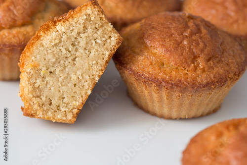 Cupcake cut in half in front of several muffins on a white background