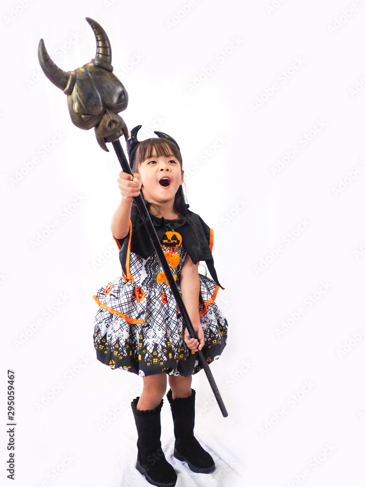 Asian children girl in pumpkin dress costume for Halloween decoration with sceptre in white background Asian children girl in pumpkin dress costume for Halloween decoration with sceptre in white background