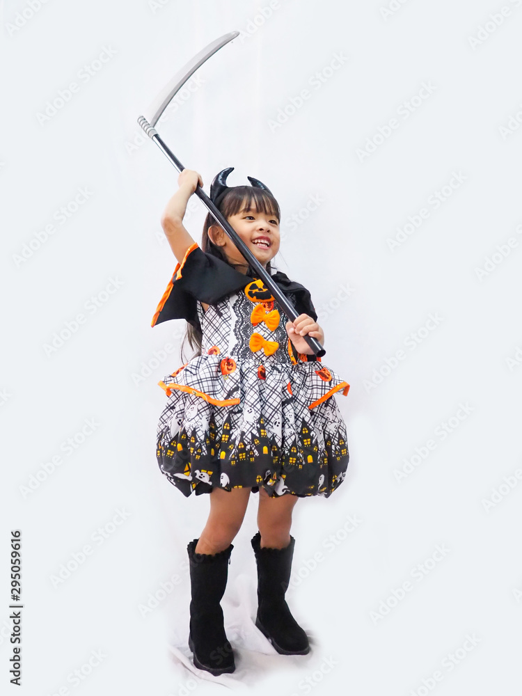 Asian children girl in pumpkin dress costume for Halloween decoration and sickle of witch in  white background