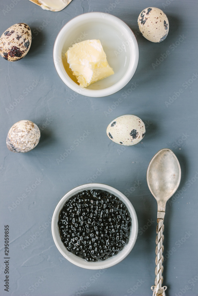 Top view of black caviar in white ceramic bowl.