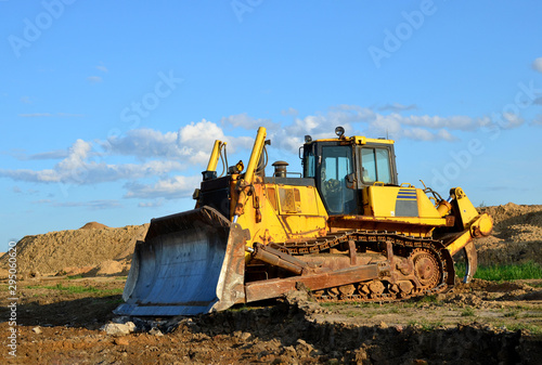 Track-type bulldozer, earth-moving equipment. Land clearing, grading, pool excavation, utility trenching, utility trenching and foundation digging during of large construction jobs.