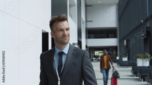 Wallpaper Mural Medium shot of elegant Caucasian businessman going along airport, looking around and smiling Torontodigital.ca
