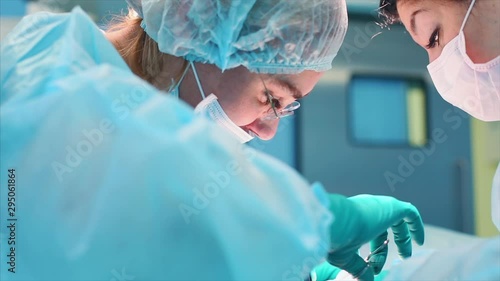 A team of surgeons has a major plan during surgery, a blue light operating room, a rhinoplasty operation to improve the aesthetics of the nose. Medetsina, plastic surgery.