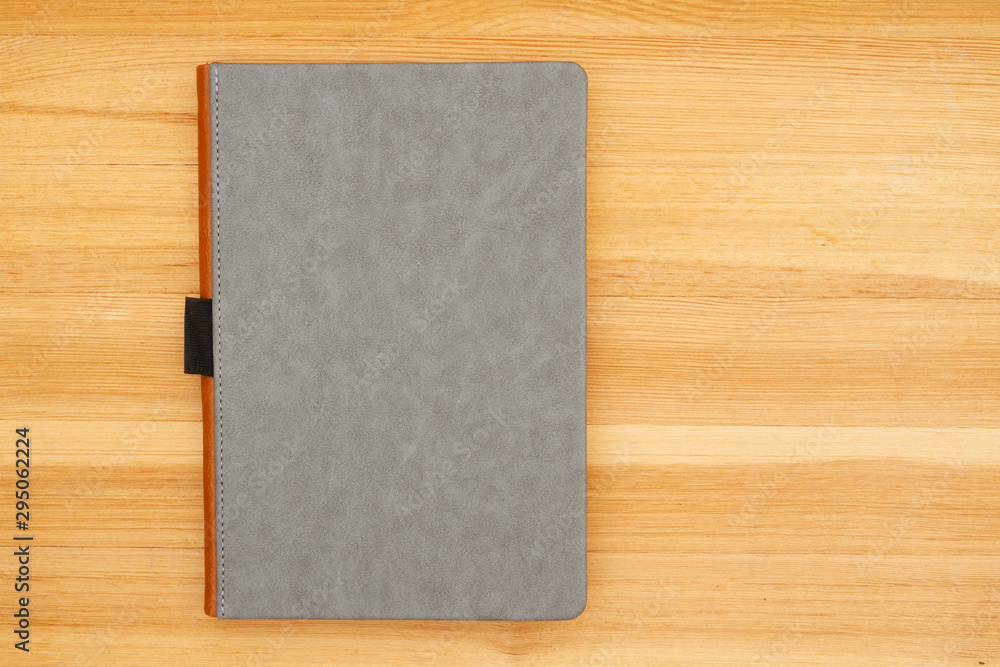 Blank gray journal on a wood desk background Blank gray journal on a wood desk background