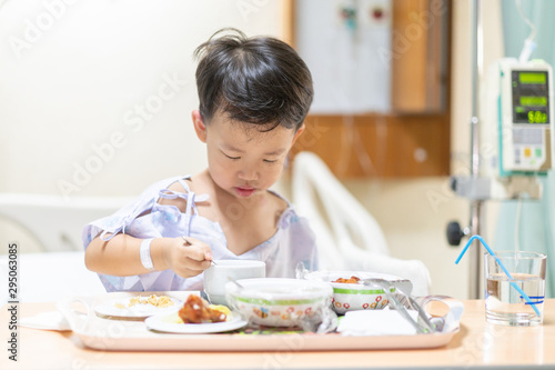 A patient boy is bored with food while he sick in the hospital.
