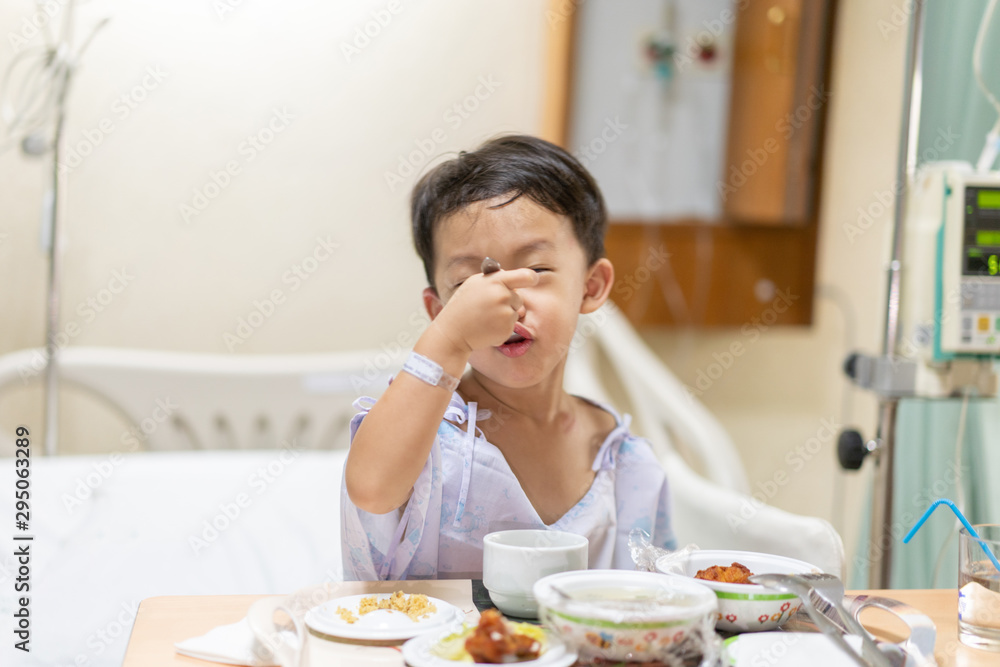 A patient boy is eatting food while he sick in the hospital. A patient boy is eatting food while he sick in the hospital.