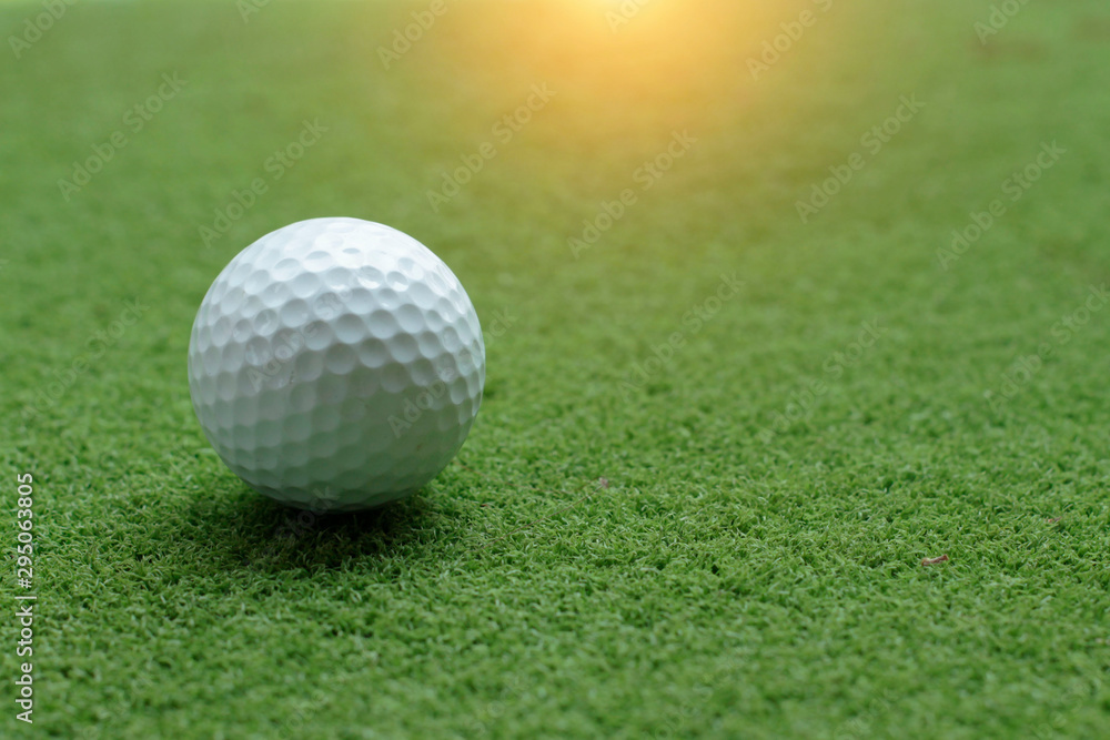 Golf ball on green grass in the evening golf course Golf ball on green grass in the evening golf course