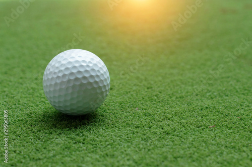 Golf ball on green grass in the evening golf course