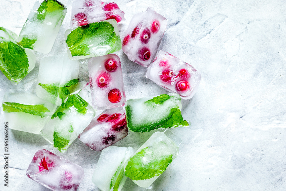 frozen red berries in ice cubes on stone background top view frozen red berries in ice cubes on stone background top view