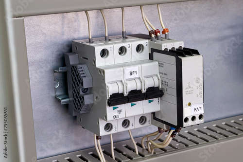 Modular circuit breaker and phase change control relay on the circuit Board in the electrical Cabinet. The devices are connected to the mains by electrical wires. Convenient and modern technology.