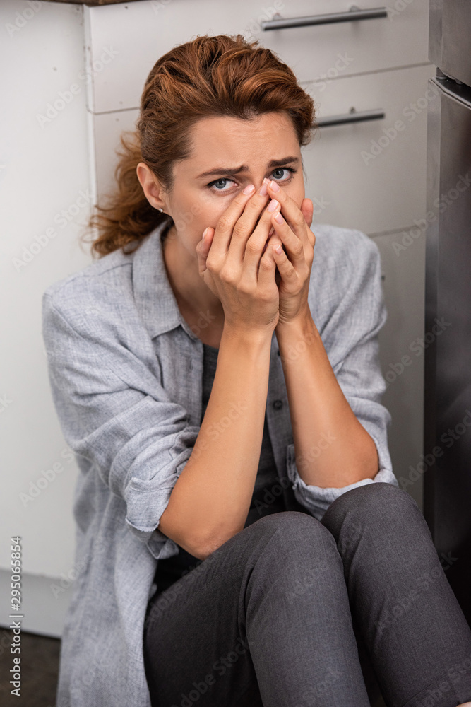 sad woman covering face and looking at camera sad woman covering face and looking at camera