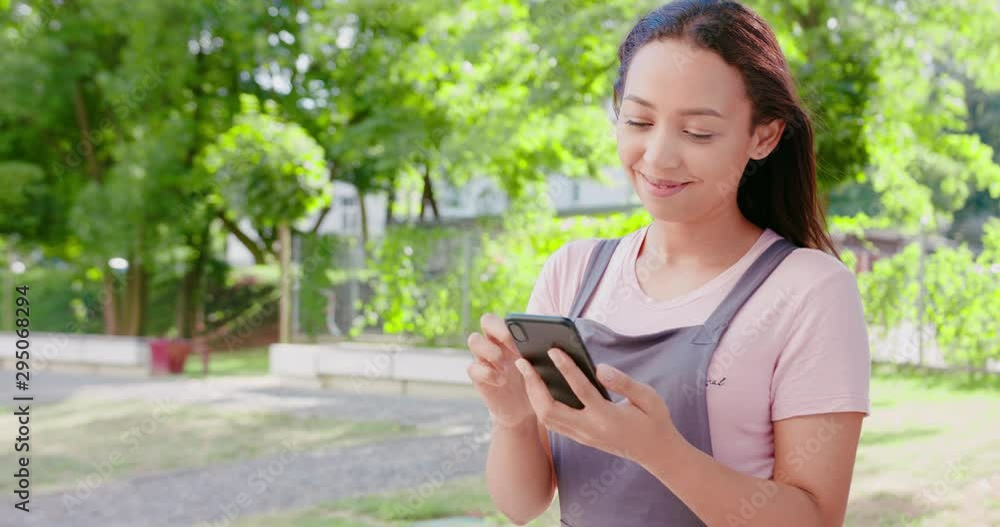 A young beautiful lady using a phone outdoors. A young beautiful lady using a phone outdoors.