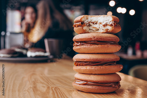 Close up Traditional chocolate and Pumpkin Whoopie pies filled made with vanilla cream cheese in cozy cafe background photo